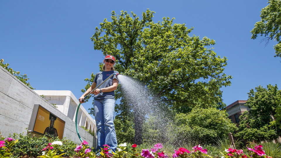 Karen Wilson with Landscape Services waters the flowers outside of the Sheldon Art Museum on City Campus. June 11, 2020. Photo by Craig Chandler | University Communication