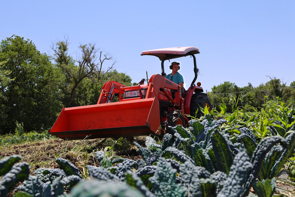 Aaron French works on a tractor at City Sprouts urban farm in Omaha, Neb.